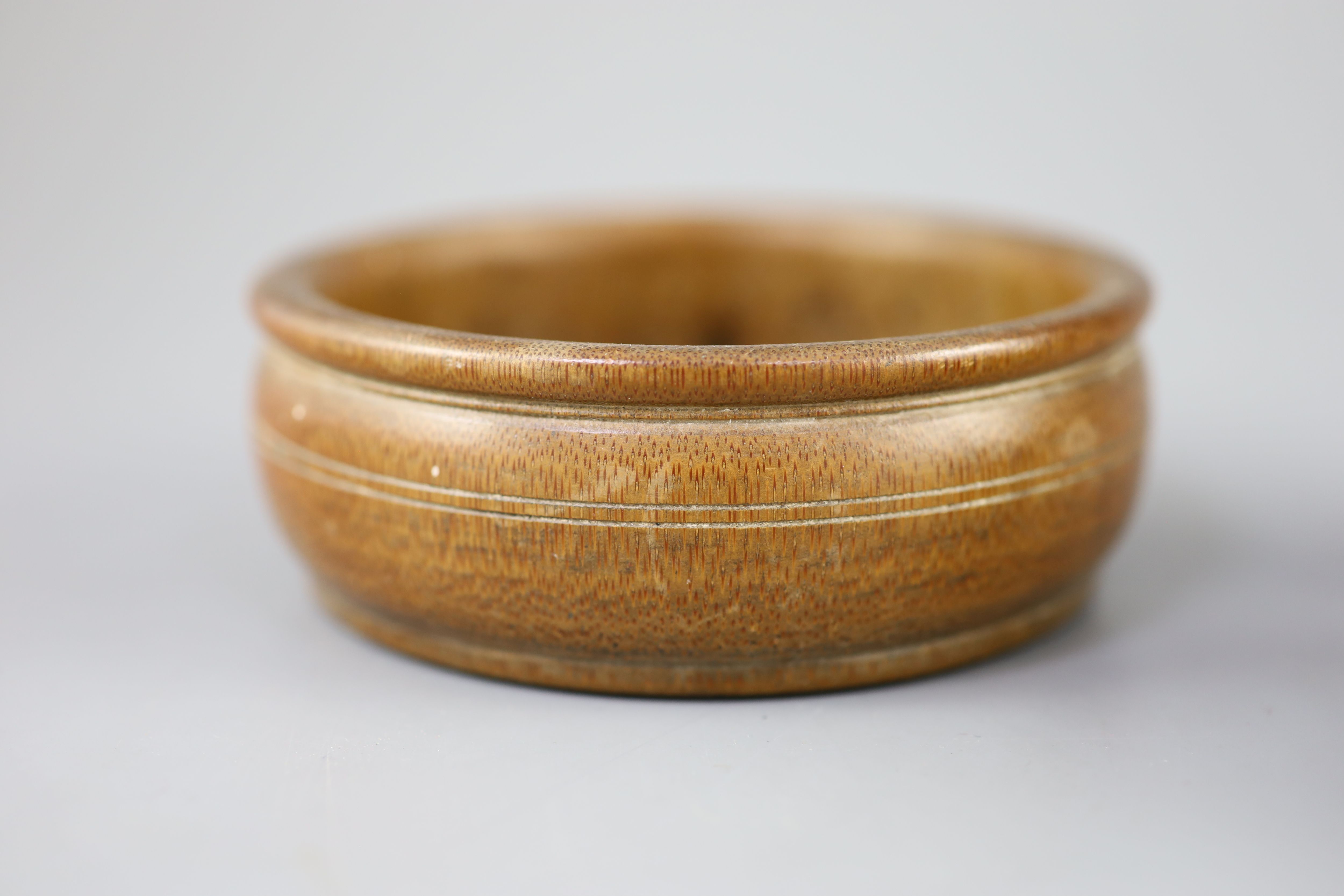A Chinese carved bamboo cup, a plain bamboo brushwasher, 18th/19th century and a gilt decorated lacquer saucer dish, 17th century,